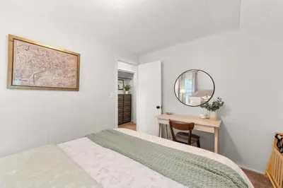a bedroom with a bed and a mirror and a table at Walkable Neighborhood of Kamm's Corners in Cleveland