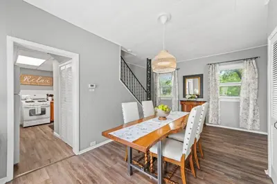a dining room with a wooden table and white chairs at Double the Space for Large Groups Entire Duplex in Cleveland