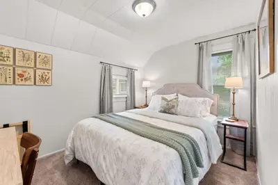 a white bedroom with a bed and a window at Double the Space for Large Groups Entire Duplex in Cleveland