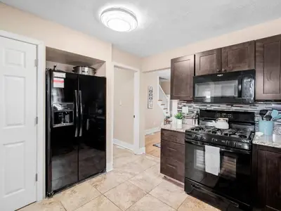 a kitchen with black appliances and wooden cabinets at Cleveland 3 Bedroom, 10 Mins to Downtown in Cleveland