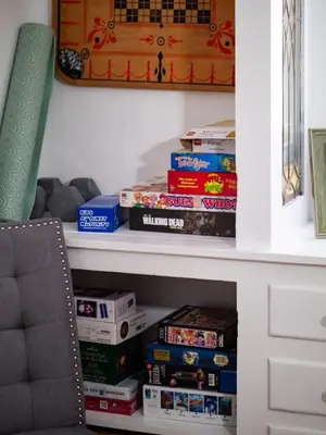 a book shelf filled with games and books at 6 Bedroom Entire Duplex for Large Groups in Cleveland