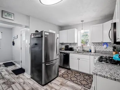 a kitchen with stainless steel appliances and white cabinets at 6 Bedroom Entire Duplex for Large Groups in Cleveland