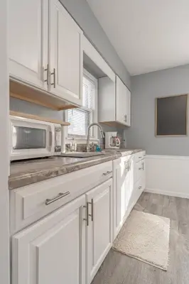 a kitchen with white cabinets and a microwave at The Ranch on RaceStreet in Marion