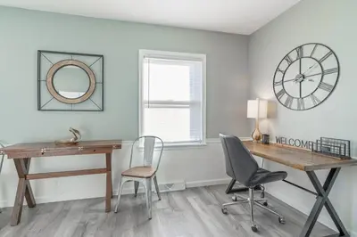 a desk and chairs in a room with a clock at The Ranch on RaceStreet in Marion