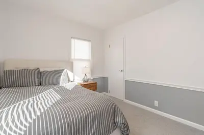 a white bedroom with a bed and a window at The Ranch on RaceStreet in Marion