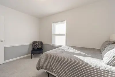 a bedroom with a bed and a chair and a window at The Ranch on RaceStreet in Marion