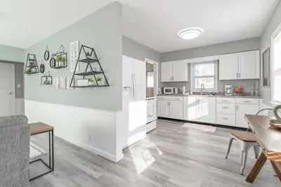 a kitchen and dining room with white cabinets and a table at The Ranch on RaceStreet in Marion