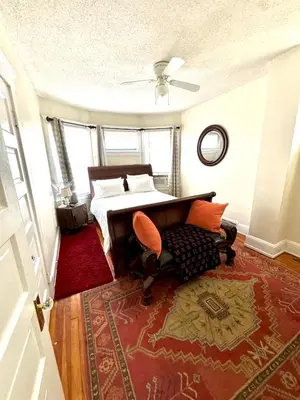 a bedroom with a bed and a table and a chair at Cozy Home By University Circle VA,CC & Museum in Cleveland