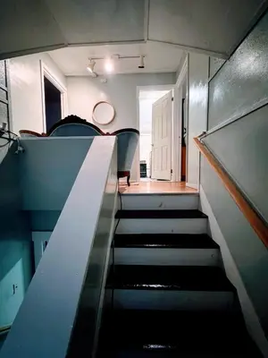 a staircase in a room with chairs and a stair case at Cozy Home By University Circle VA,CC & Museum in Cleveland