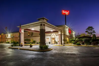 a hotel with a sign in a parking lot at Red Roof Inn Carrollton in Carrollton