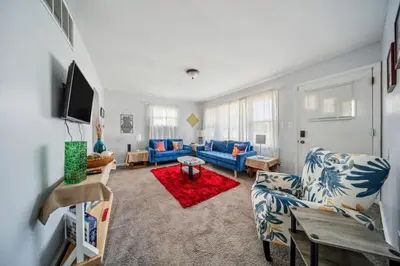 a living room with blue couches and a red rug at Cozy two bedroom one bath in Cleveland