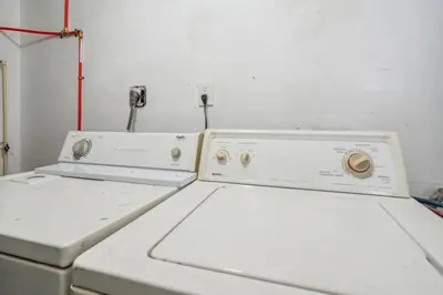 two washing machines sitting next to each other in a room at Cozy two bedroom one bath in Cleveland