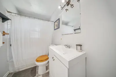 a white bathroom with a toilet and a sink at Cozy two bedroom one bath in Cleveland
