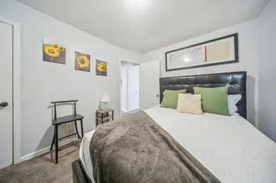 a bedroom with a large bed with green pillows at Cozy two bedroom one bath in Cleveland
