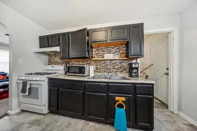 a kitchen with black cabinets and a sink at Cozy two bedroom one bath in Cleveland