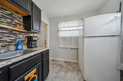 a kitchen with a white refrigerator and a sink at Cozy two bedroom one bath in Cleveland