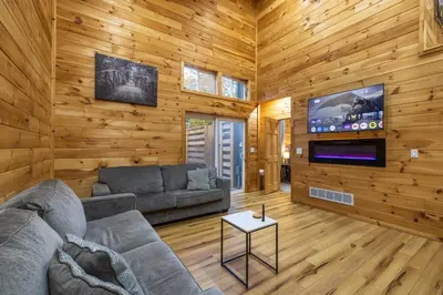 a living room with a couch and a tv at New listing-- Hocking Hills Modern Cabin in Logan