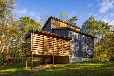 a wooden house on a hill with trees at New listing-- Hocking Hills Modern Cabin in Logan