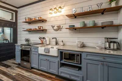 a kitchen with blue cabinets and a sink and shelves at Blame Jaime - downtown, the heart of all the fun! in Port Clinton