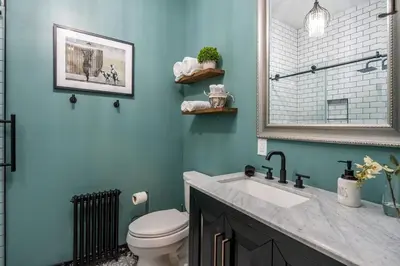 a bathroom with a toilet and a sink and a mirror at Blame Jaime - downtown, the heart of all the fun! in Port Clinton