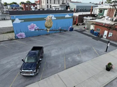 a truck parked in a parking lot with a painting of a sheep at Blame Jaime - downtown, the heart of all the fun! in Port Clinton