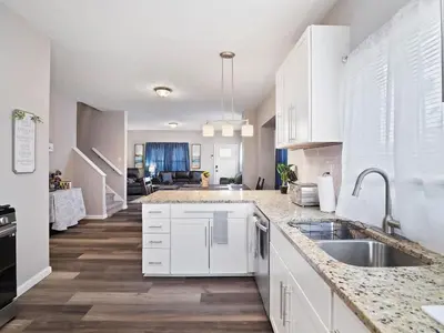a kitchen with white cabinets and a sink at Large Remodeled 4 Bedroom Only 7 Minutes to Downtown in Cleveland