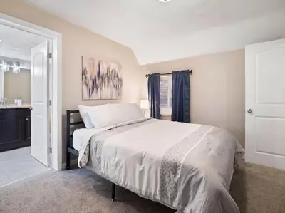 a bedroom with a large bed and a bathroom at Large Remodeled 4 Bedroom Only 7 Minutes to Downtown in Cleveland