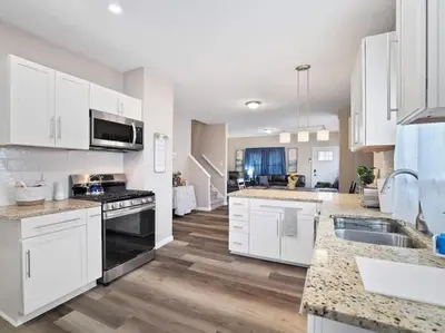 a kitchen with white cabinets and a counter top at Large Remodeled 4 Bedroom Only 7 Minutes to Downtown in Cleveland