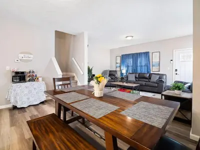 a kitchen and living room with a wooden table at Large Remodeled 4 Bedroom Only 7 Minutes to Downtown in Cleveland