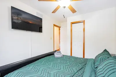 a bedroom with a bed and a flat screen tv at Comfort Awaits at Cozy Get Away - Dog Friendly in Akron