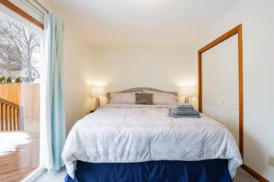a bedroom with a bed and a large window at Comfort Awaits at Cozy Get Away - Dog Friendly in Akron