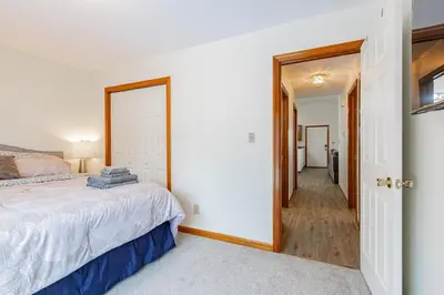 a bedroom with a bed and a hallway at Comfort Awaits at Cozy Get Away - Dog Friendly in Akron