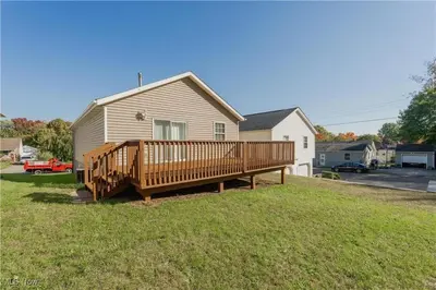 a large wooden deck in the yard of a house at Comfort Awaits at Cozy Get Away - Dog Friendly in Akron