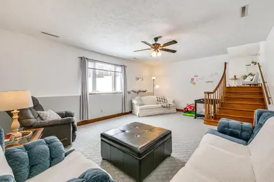 a living room with couches and a ceiling fan at Secluded Ohio Amish Country Getaway with Fire Pit in Sugarcreek