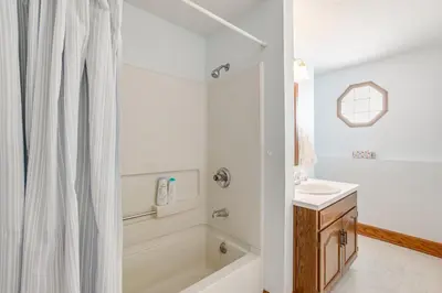a white bathroom with a tub and a sink at Secluded Ohio Amish Country Getaway with Fire Pit in Sugarcreek