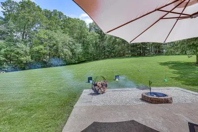 a backyard with a fire pit and an umbrella at Secluded Ohio Amish Country Getaway with Fire Pit in Sugarcreek