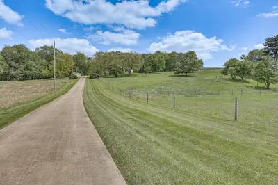 a dirt road in a field with a fence at Secluded Ohio Amish Country Getaway with Fire Pit in Sugarcreek