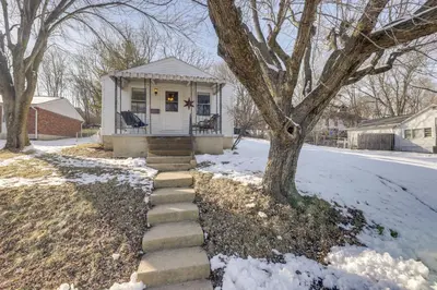 a small white house with a tree in the snow at 3 Mi to Englewood Dam Pet-Friendly Home with Yard! in Englewood