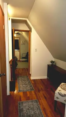 an attic room with a staircase and a hallway with rugs at The Best of Cave Run & Morehead! in Morehead