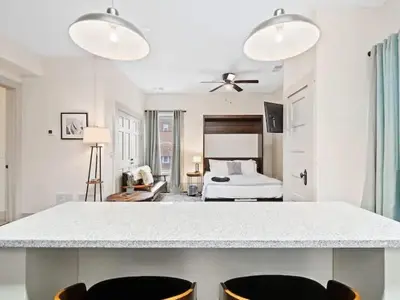a white room with a bed and a table and chairs at Victorian Estates - Cute Stuido - Steps To Clinic in Cleveland