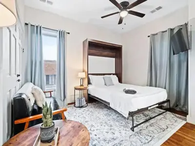 a bedroom with a bed and a table and a fan at Victorian Estates - Cute Stuido - Steps To Clinic in Cleveland