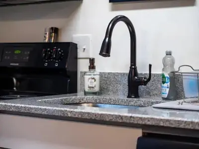 a kitchen counter with a sink and a faucet at Victorian Estates - Cute Stuido - Steps To Clinic in Cleveland
