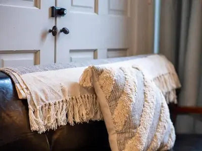 a blanket on the back of a couch at Victorian Estates - Cute Stuido - Steps To Clinic in Cleveland