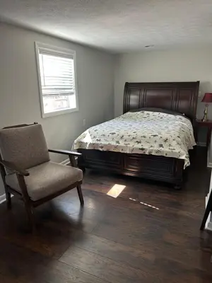 a bedroom with a bed and a chair and a window at Country Getaway in Stewart