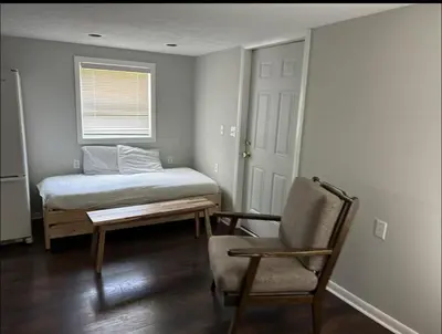 a bedroom with a bed and a chair and a window at Country Getaway in Stewart