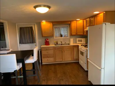 a kitchen with wooden cabinets and a white refrigerator at Country Getaway in Stewart