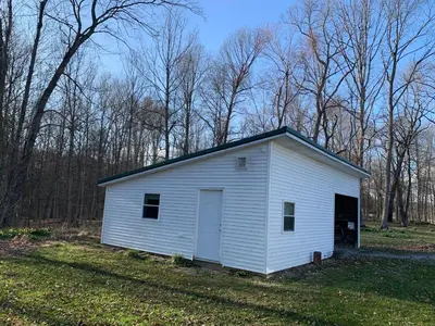 a small white building in the middle of a field at Country Getaway in Stewart