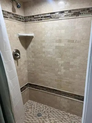 a bathroom with a shower with a tiled shower at Modern Glass City Home in Toledo