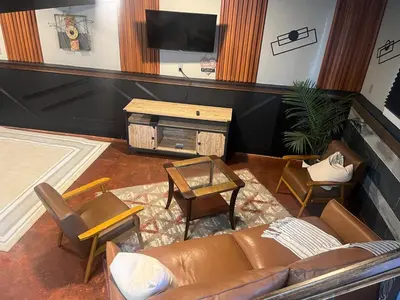 a living room with a couch and a tv at Modern Glass City Home in Toledo