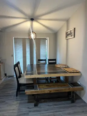 a dining room with a wooden table and chairs at Modern Glass City Home in Toledo